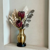 High Objects Aurelia Vase: brushed gold metallic vase with black base, holding dried protea flowers and foliage.
