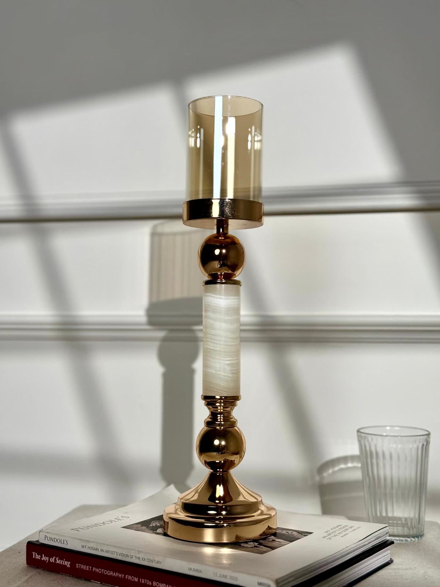 High Objects Aurora Column Candle Stand Set with amber glass shade, gold metal accents, and white marble-effect column.