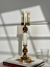 High Objects Aurora Column Candle Stand Set with amber glass shade, gold metal accents, and white marble-effect column.