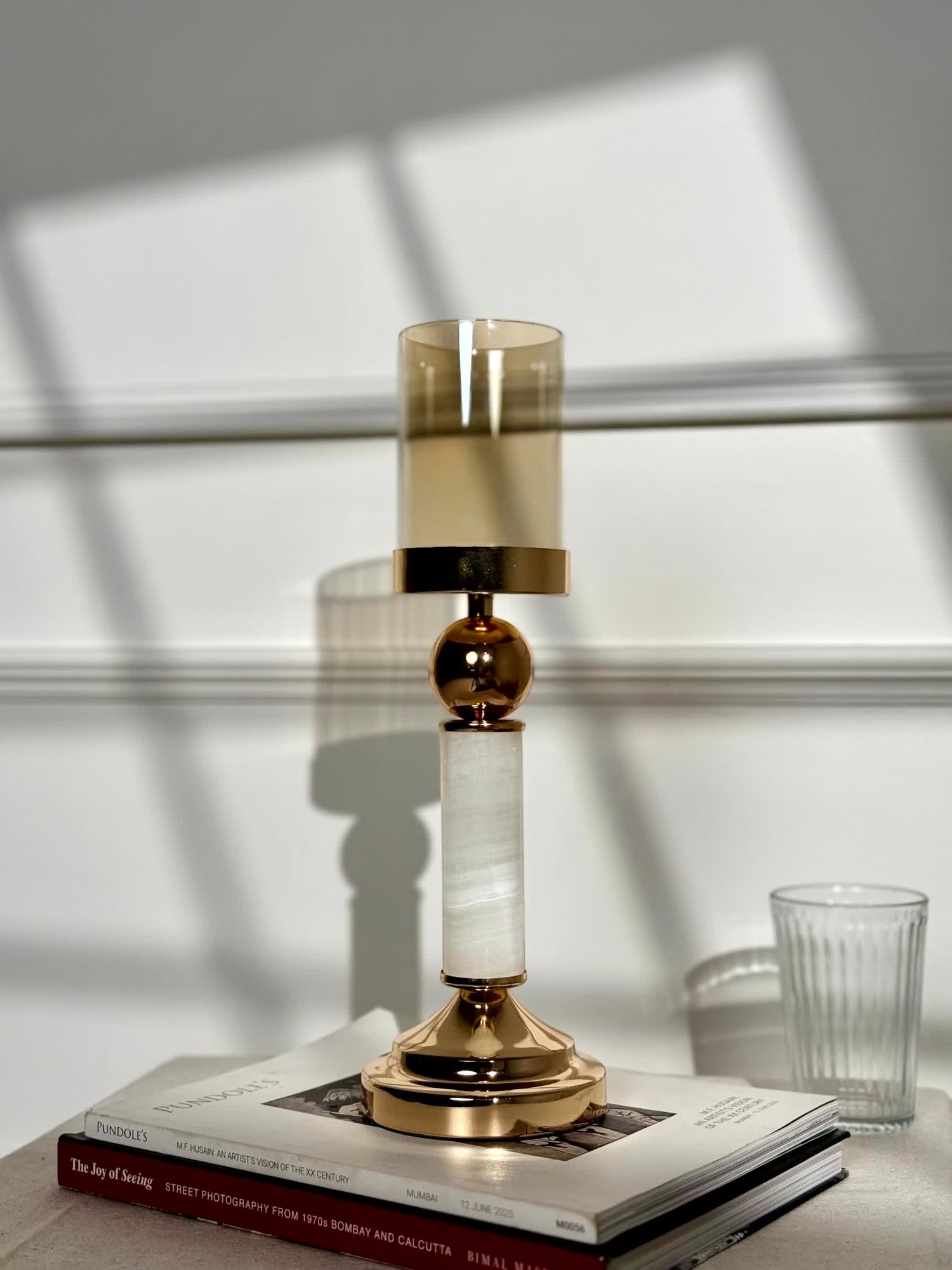High Objects Aurora Column Candle Stand Set with gold accents, white stone column, and amber glass holder.