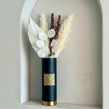 High Objects Aurum Noir matte black cylindrical vase with textured gold band and base, holding dried floral arrangement.