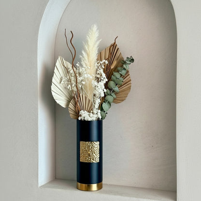 High Objects Aurum Noir matte black cylindrical vase with textured gold band and base, holding dried floral arrangement.