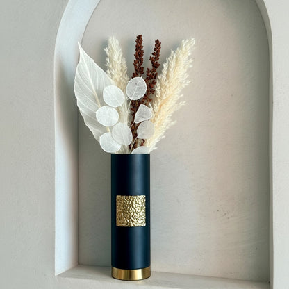 High Objects Aurum Noir matte black cylindrical vase with textured gold band and base, holding dried floral arrangement.