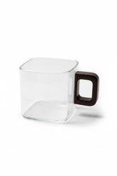 High Objects AXISFORM™ square glass cup with a dark geometric handle, perfect for modern coffee or tea rituals.