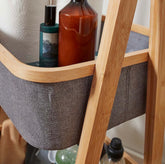 High Objects natural bamboo frame storage organizer with grey fabric baskets holding toiletries and paper towels.