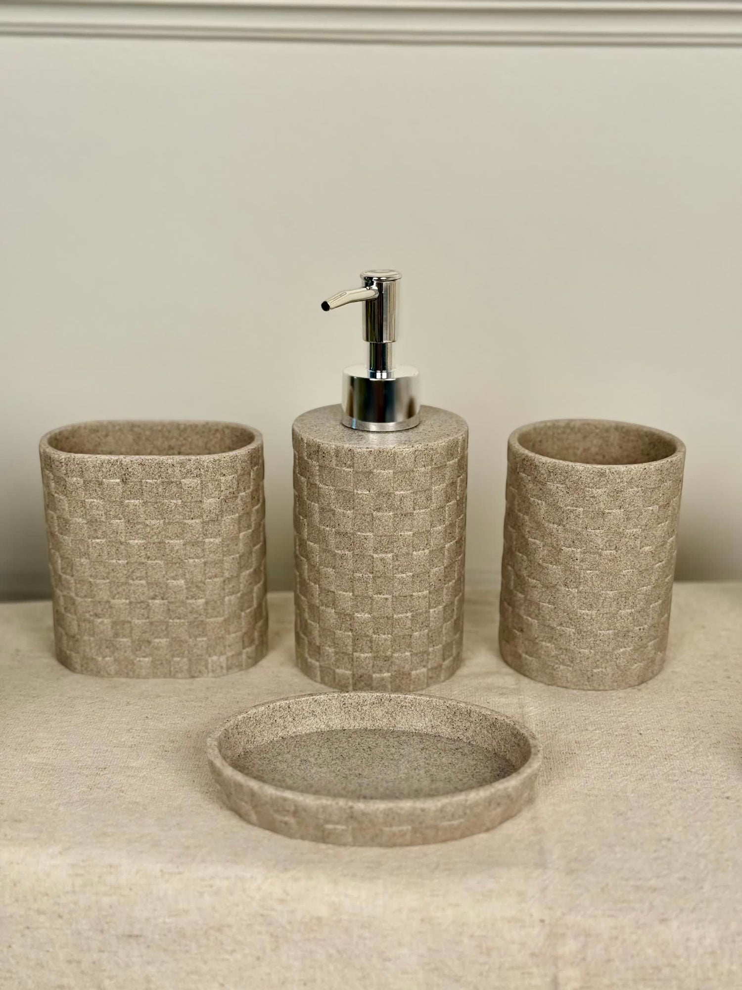 High Objects Weaveform Bathroom Accessory Set in beige with woven texture. Includes soap dispenser, toothbrush holder, cup, and soap dish.