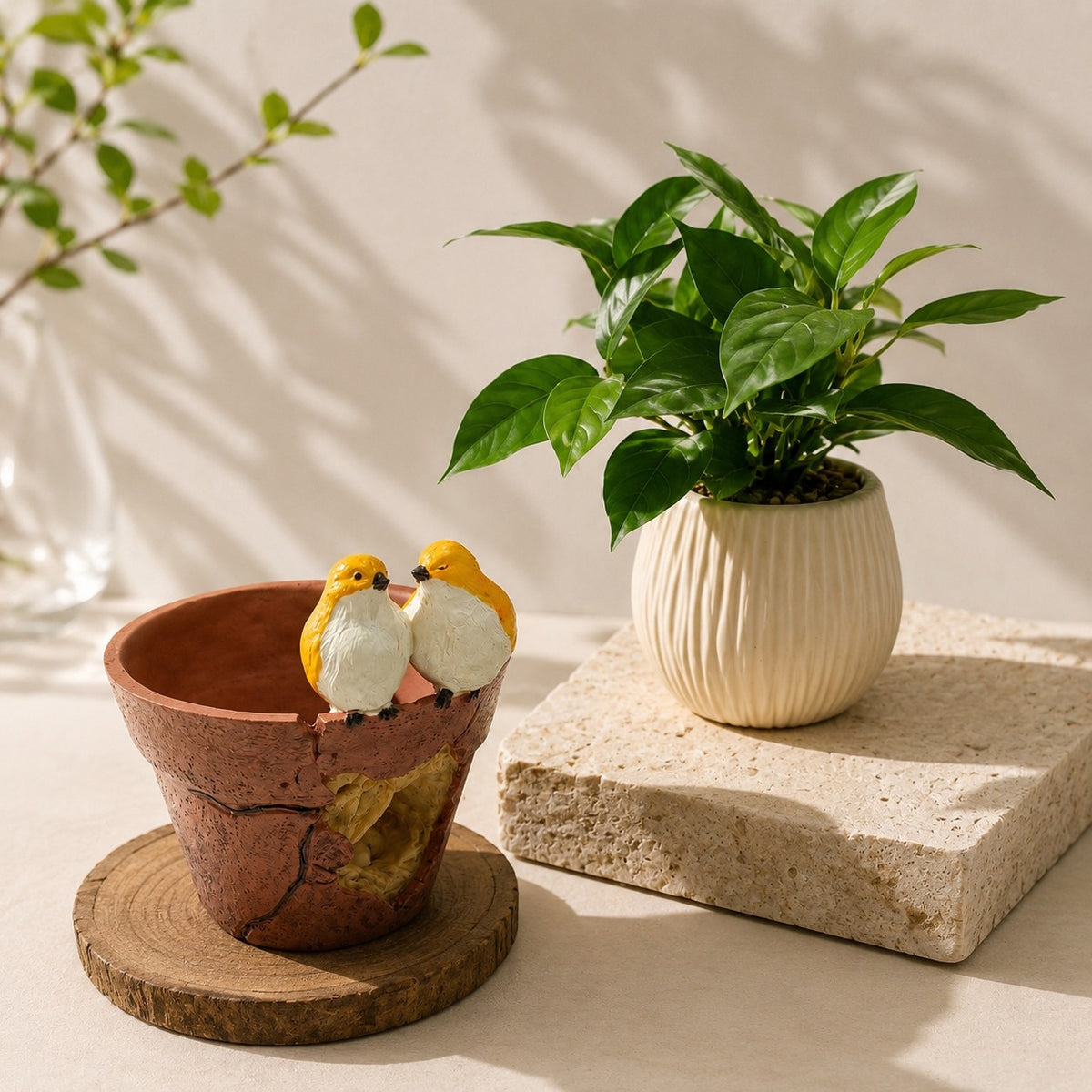High Objects decorative terracotta-style planter with two yellow birds perched on the rim next to a potted green plant