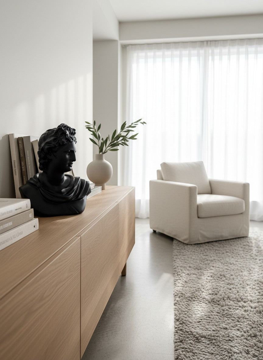 High Objects black bust showpiece on a wooden cabinet with books and a vase with greenery.