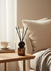 High Objects Blossom Reed Aroma Diffuser in amber glass bottle with floral design and black reeds, 50ml.