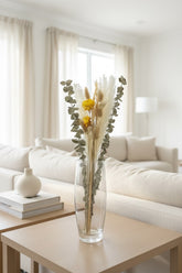 High Objects Botanical Golden Whisper dried flower arrangement with pampas grass, eucalyptus, and golden strawflowers in a glass vase.