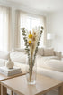 High Objects Botanical Golden Whisper dried flower arrangement with pampas grass, eucalyptus, and golden strawflowers in a glass vase.