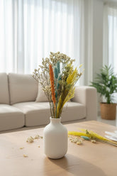 High Objects Botanical Sunlit Meadow dried flower arrangement with golden yellow, teal, and orange accents in a white vase.