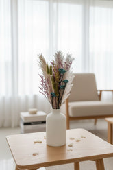 High Objects Botanical Velvet Meadow dried flower arrangement with pampas grass, bunny tails, magenta florals, golden seed spikes, and teal berries in a white vase.