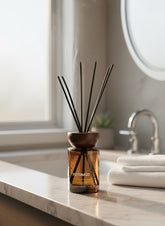 High Objects compact brown glass reed diffuser with oriental wood scent, 110ml capacity, on a marble countertop.