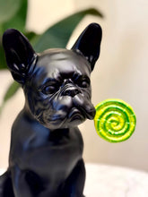 High Objects matte black French bulldog showpiece holding a green lollipop in its mouth.