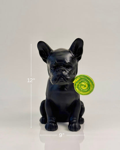 High Objects matte black French bulldog showpiece holding a green and yellow swirled lollipop in its mouth.