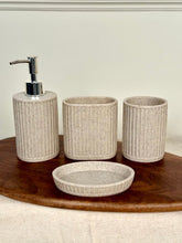 High Objects Calmridge 4-piece bathroom accessory set in beige with ribbed texture, includes soap dispenser, toothbrush holder, cup, and soap dish.