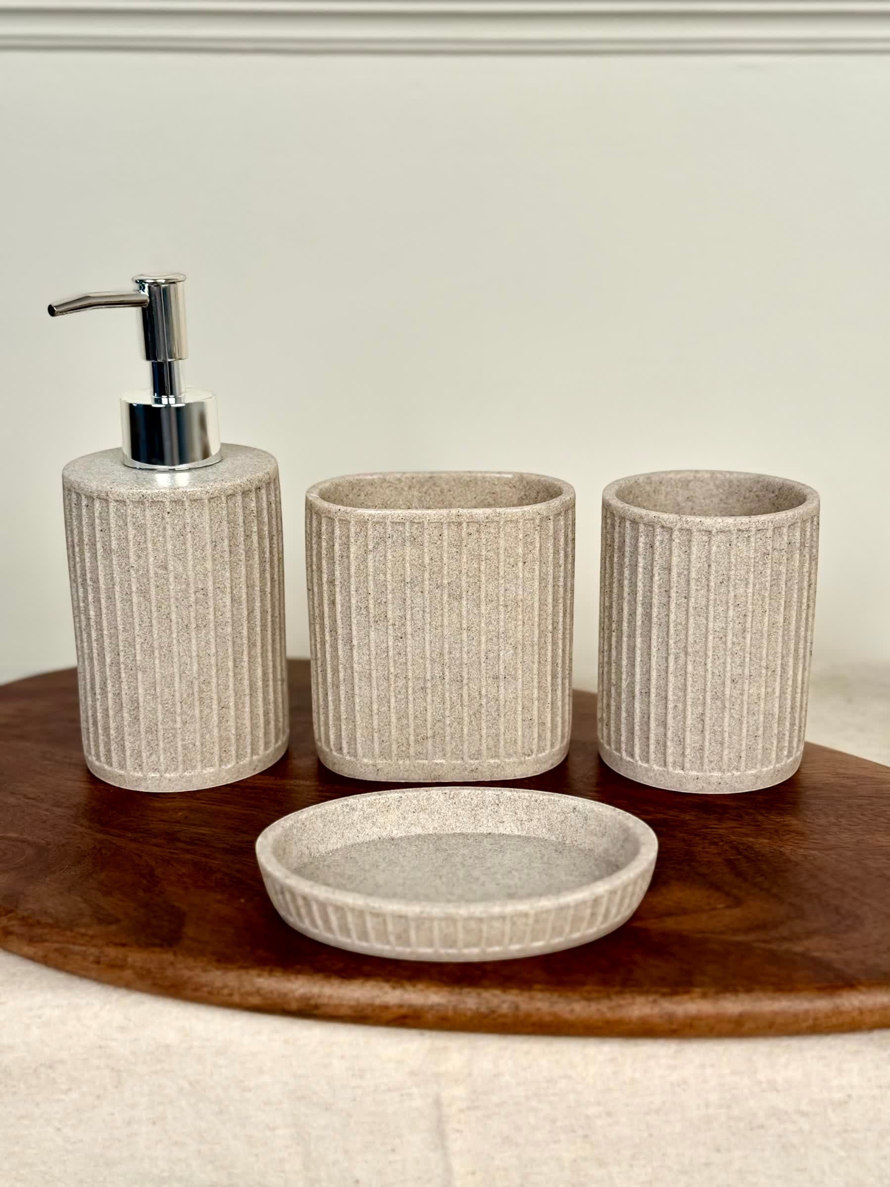 High Objects Calmridge 4-piece bathroom accessory set in beige with ribbed texture, includes soap dispenser, toothbrush holder, cup, and soap dish.