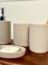 High Objects Calmridge Bathroom Accessory Set in speckled beige stone with ribbed texture. Includes soap dish, dispenser, and cups.