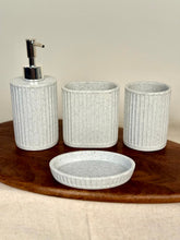 High Objects Calmridge Bathroom Accessory Set: speckled white soap dispenser, toothbrush holder, and dish with ribbed texture.