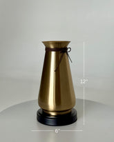 High Objects Celestia Vase, a gold tapered vase with a flared rim and cord detail, on a black base.