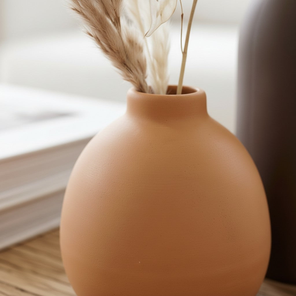 High Objects set of 3 ceramic vases in terracotta, dark brown, and cream, holding dried flowers and white blooms.