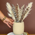 High Objects StoneAura ceramic vase with a textured matte finish, holding dried bunny tail grass.