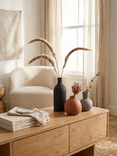High Objects matte black, terracotta, and grey ceramic vases in various rounded shapes. Minimalist decor.