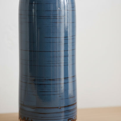 High Objects three ceramic vases in blue, yellow, and light blue with textured bases, holding various flowers.