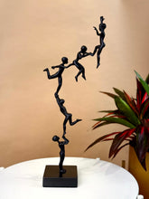 High Objects Climber Crew Artefact sculpture, matte black finish, 19-inch tall figures in a chain lifting each other.