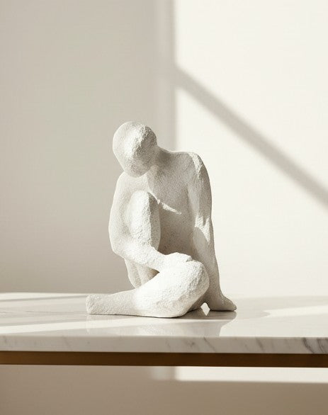 High Objects textured white abstract faceless polyresin sculpture of a seated figure in contemplation.