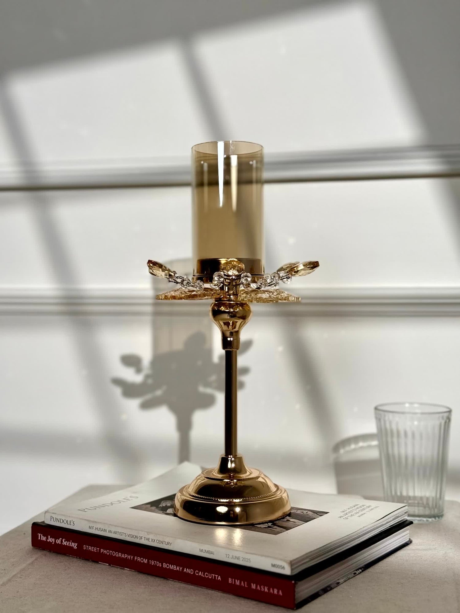 High Objects Crystal Bloom candle stand with amber glass hurricane and crystal petal accents on a gold pedestal base.