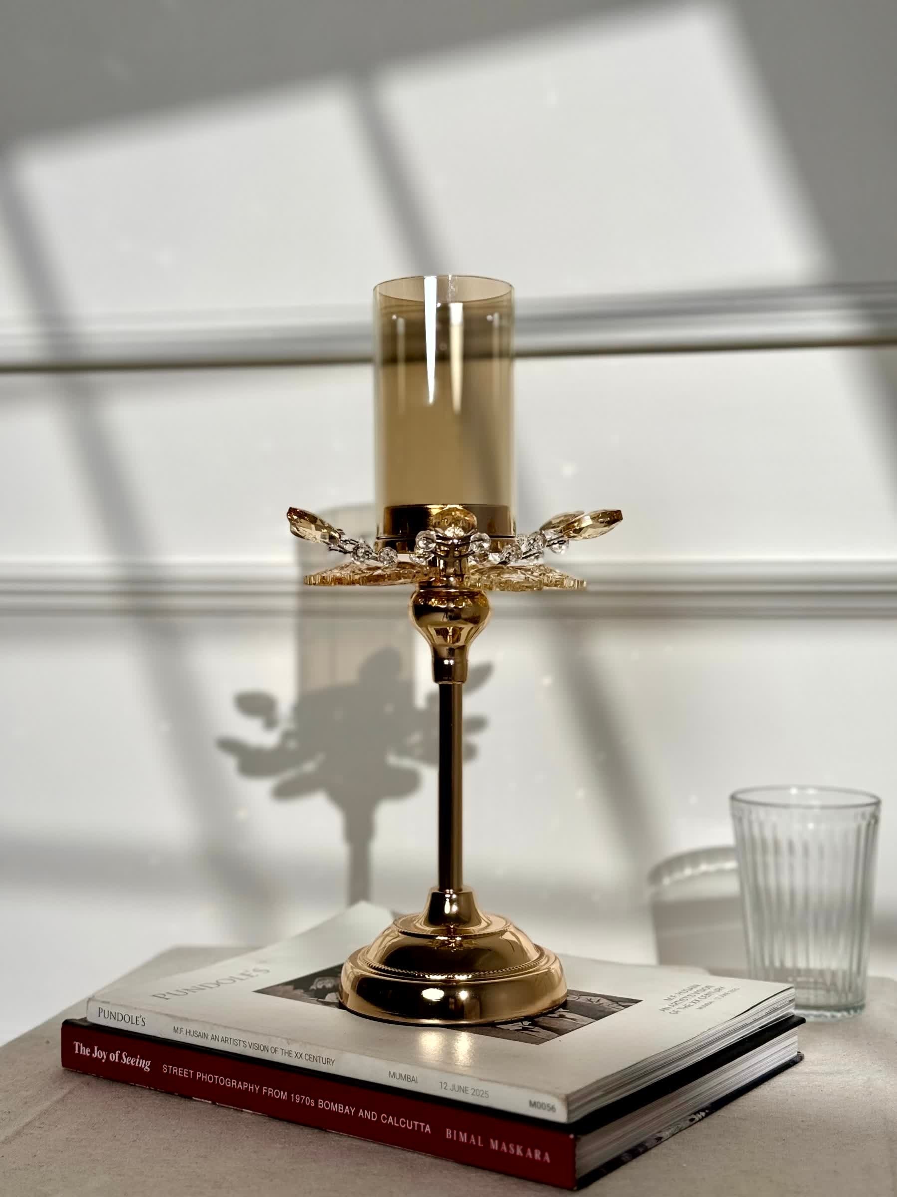 High Objects Crystal Bloom candle stand with amber glass hurricane and crystal petal accents on a gold pedestal base.