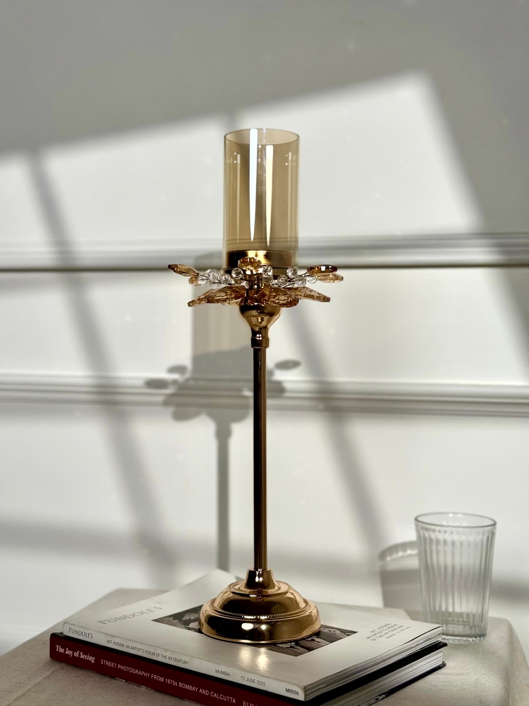 High Objects Crystal Bloom candle stand with amber glass hurricane and crystal petal accents on a gold pedestal.