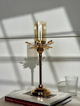 High Objects Crystal Bloom candle stand with amber glass hurricane and crystal petal accents on a rose gold base.