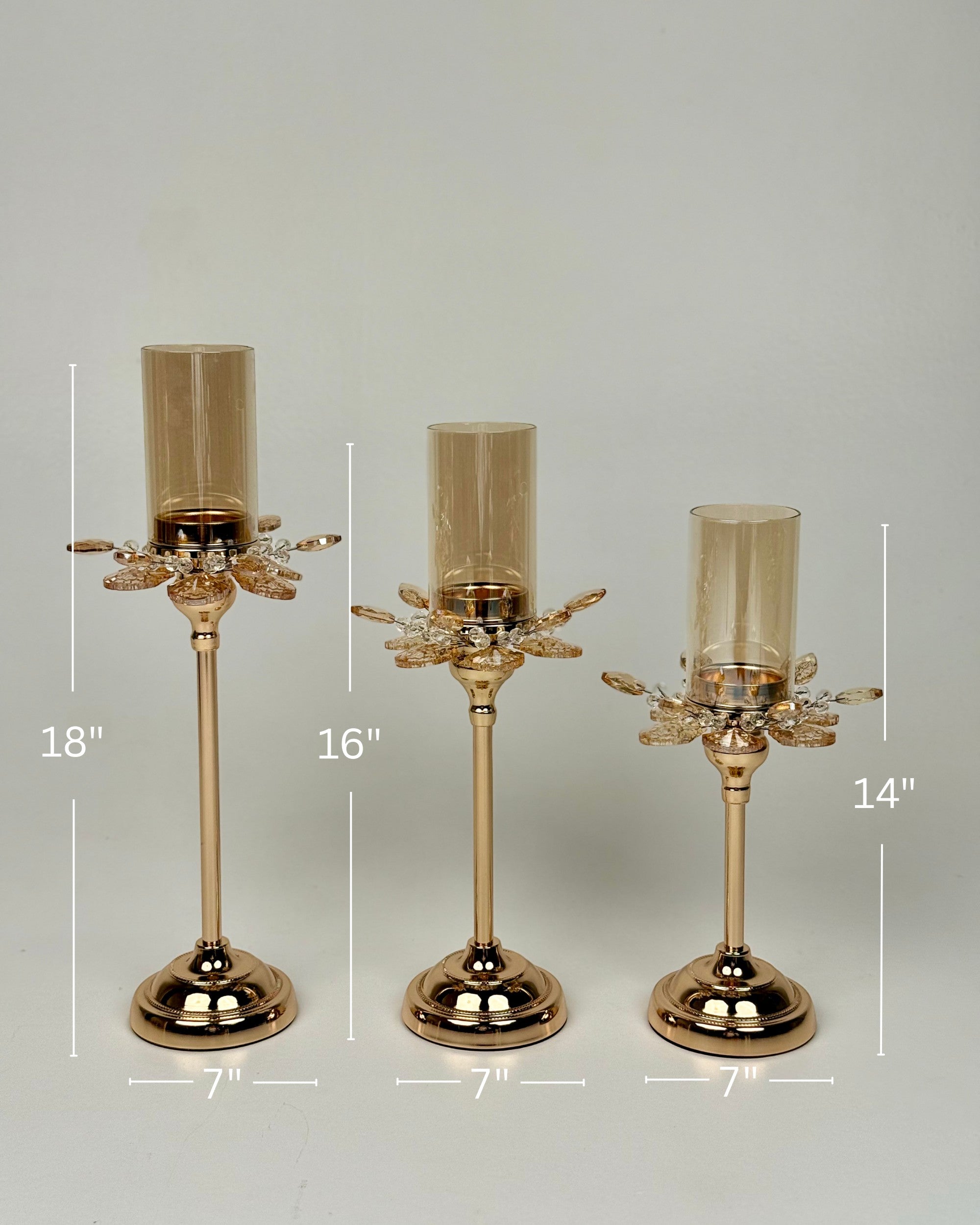 High Objects Crystal Bloom candle stand set with amber glass hurricanes and crystal petal accents, in 18", 16", and 14" heights.