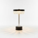 High Objects Crystal Halo Table Lamp with gold stem, black base, and crystal fringe shade casting warm light.