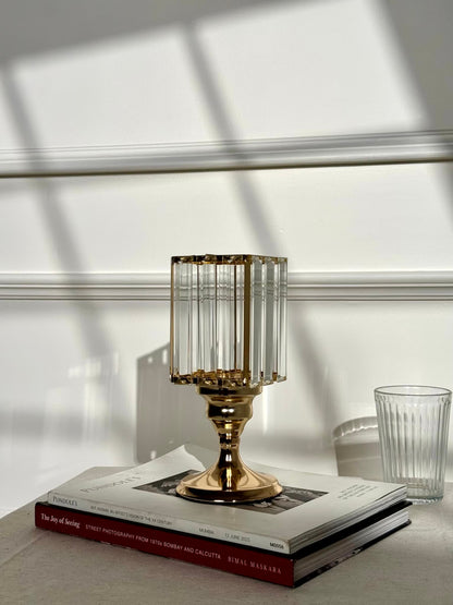High Objects Crystal Luxe candle stand with faceted glass hurricane top and gold pedestal base, styled on books.