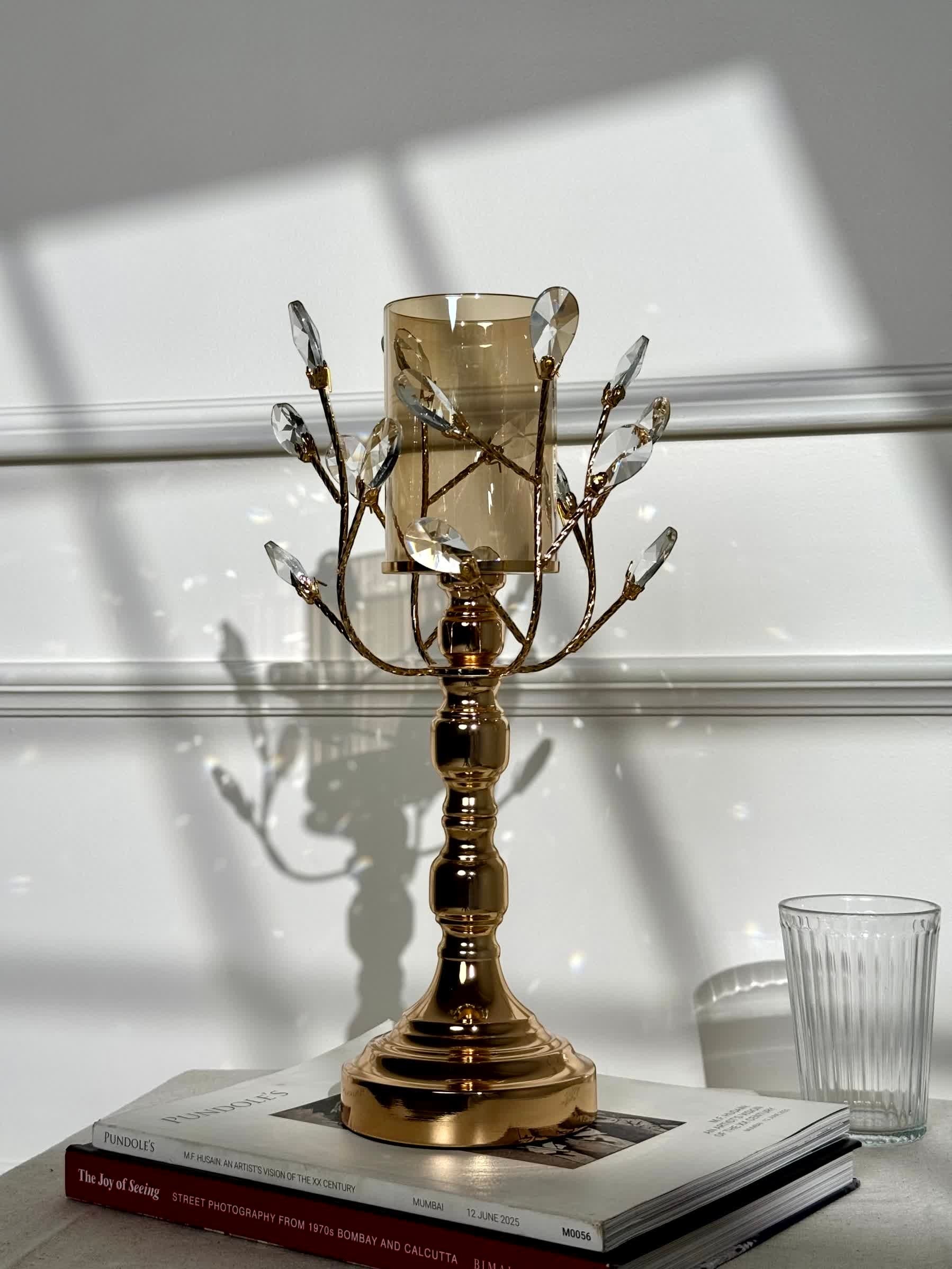 High Objects Crystal Vine Candle Stand Set with amber glass hurricane and crystal leaves on gold metal vine branches.