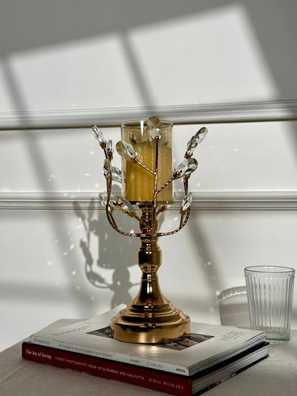 High Objects Crystal Vine Candle Stand Set with gold metal vine accents and crystal leaves holding a amber glass hurricane.