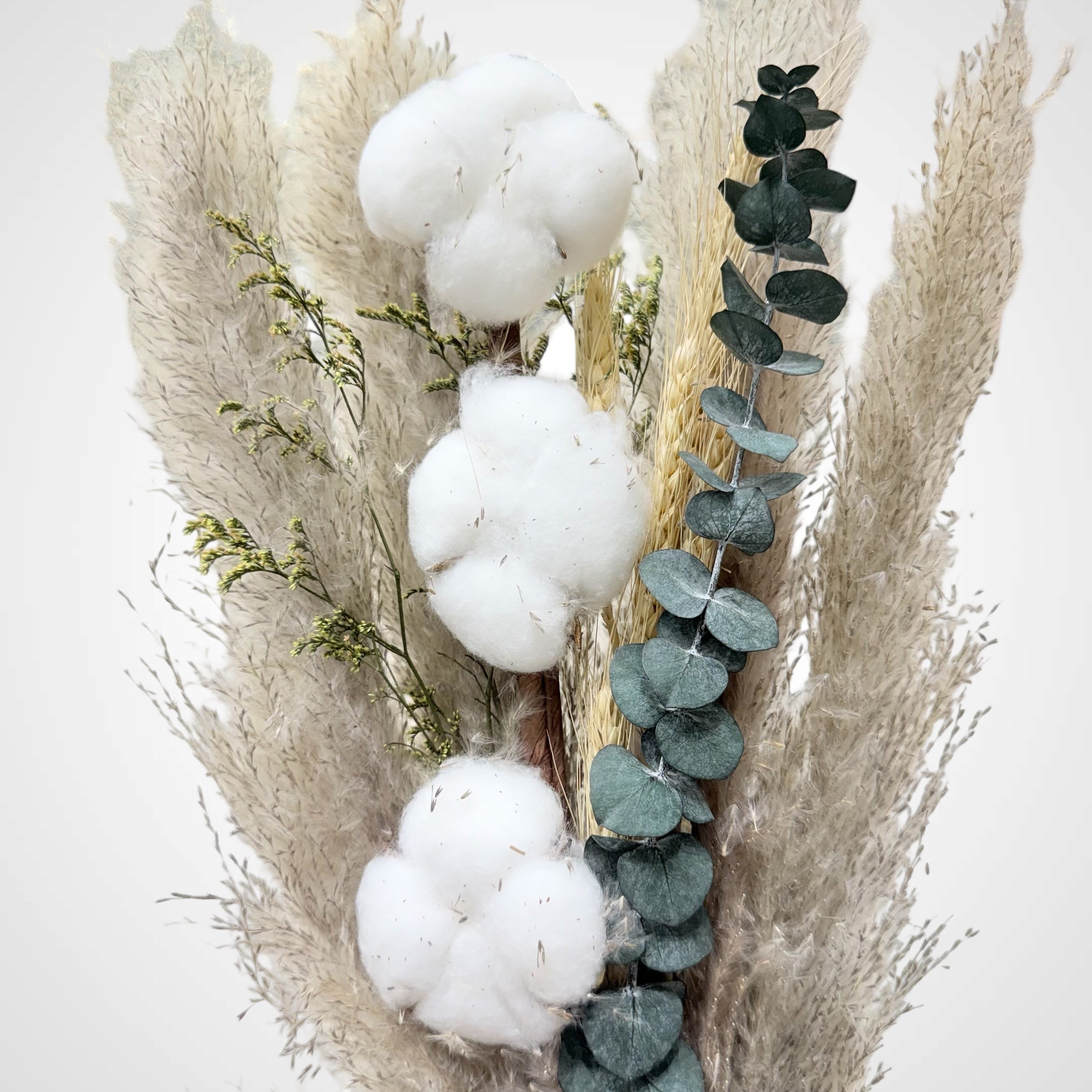 High Objects Maison Éclat dried botanical arrangement with cotton bolls, eucalyptus, grasses, and dried florals in a ceramic vessel.