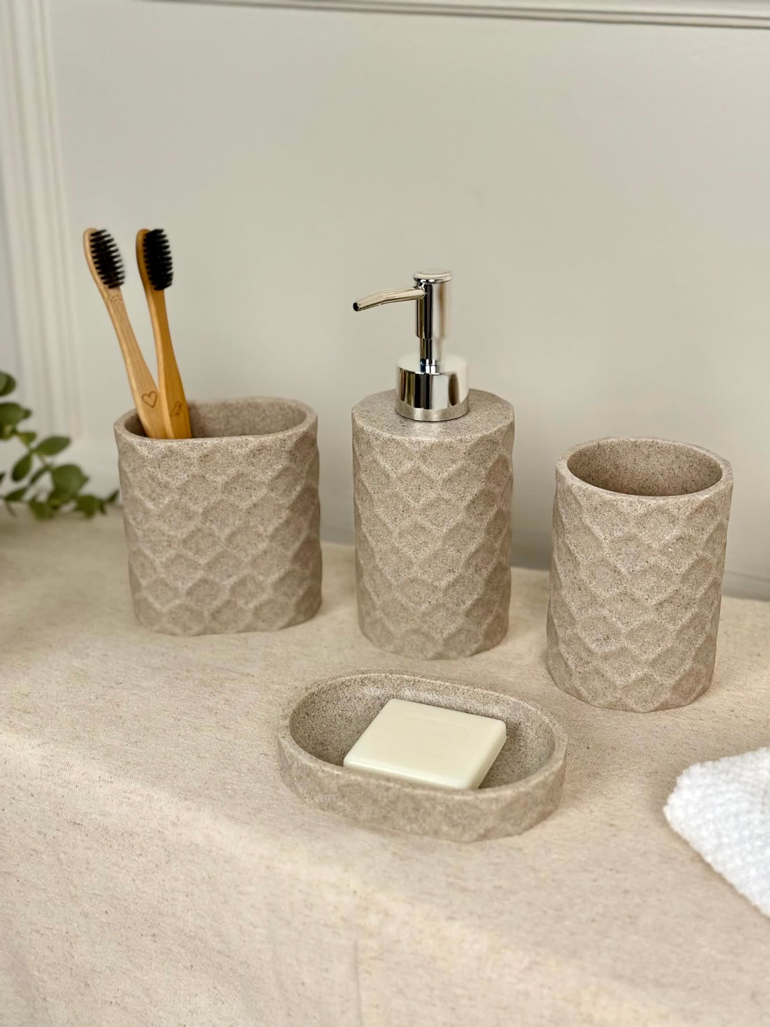 High Objects Dunecraft Bathroom Accessory Set, textured beige resin soap dish, dispenser, and two cups with toothbrushes.