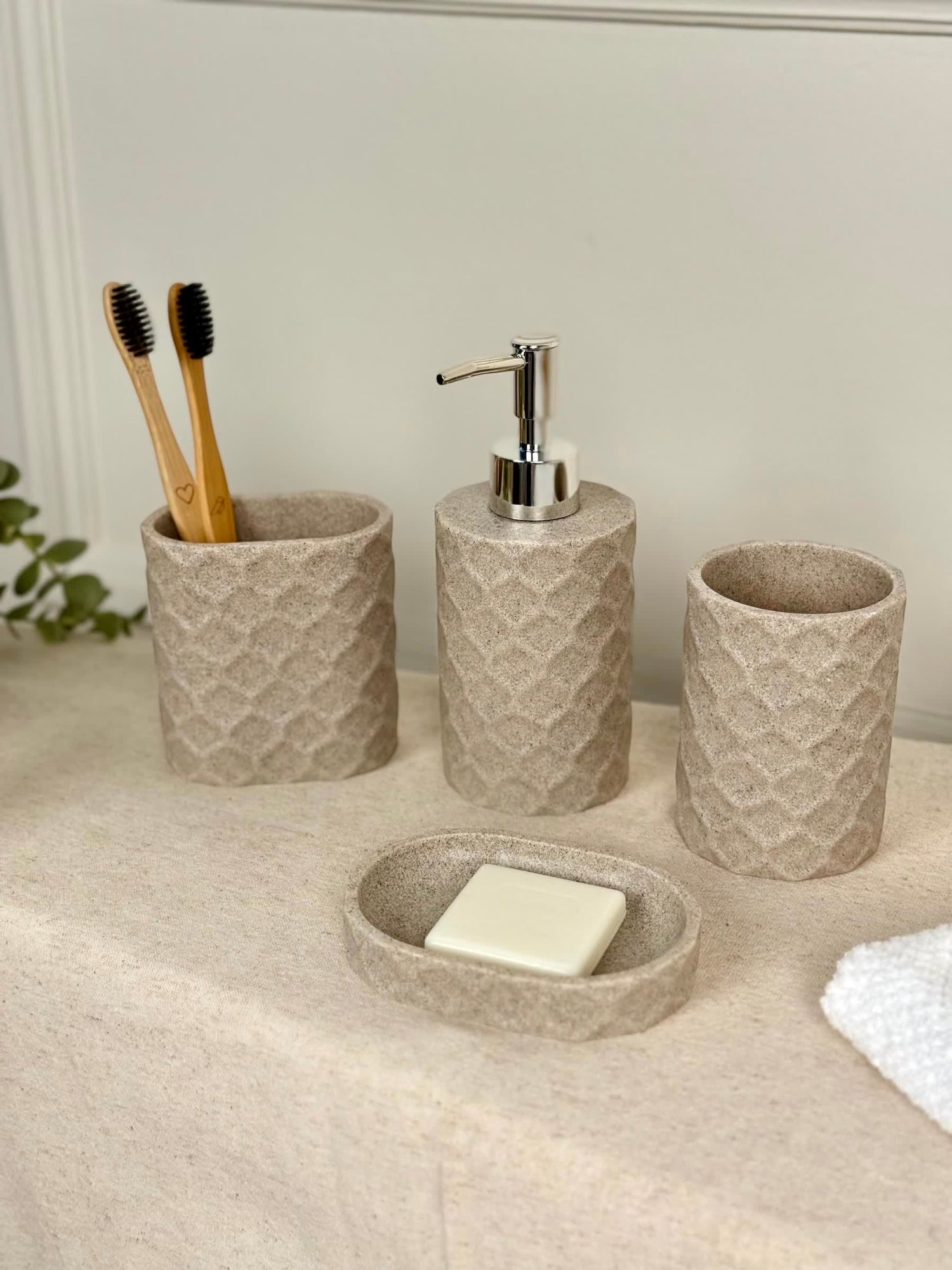 High Objects Dunecraft Bathroom Accessory Set, textured beige resin soap dish, dispenser, and two cups with toothbrushes.