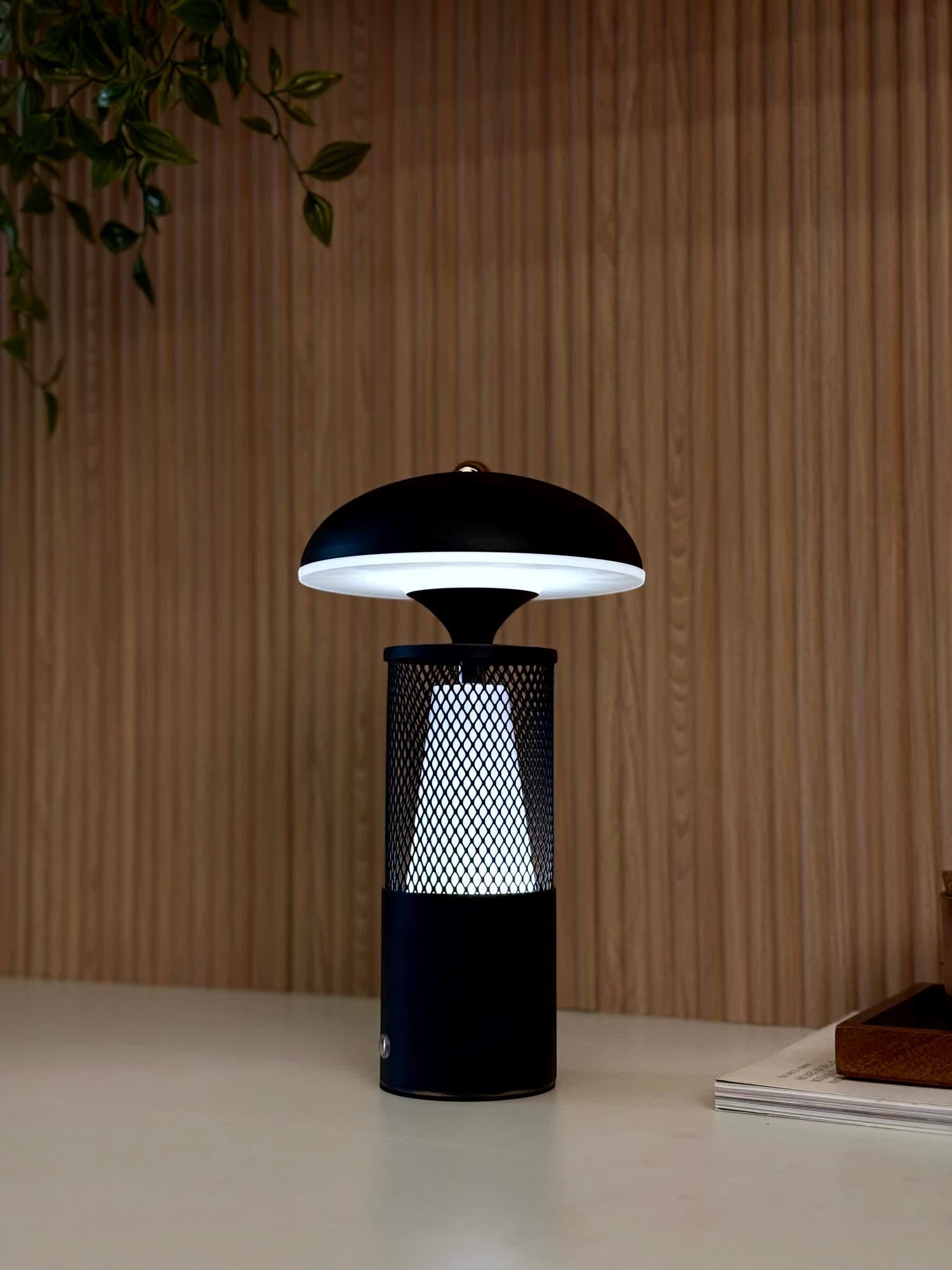 High Objects Eclipse Mesh Table Lamp in matte black with gold detailing, mushroom silhouette, textured mesh body, and diffused downward light.
