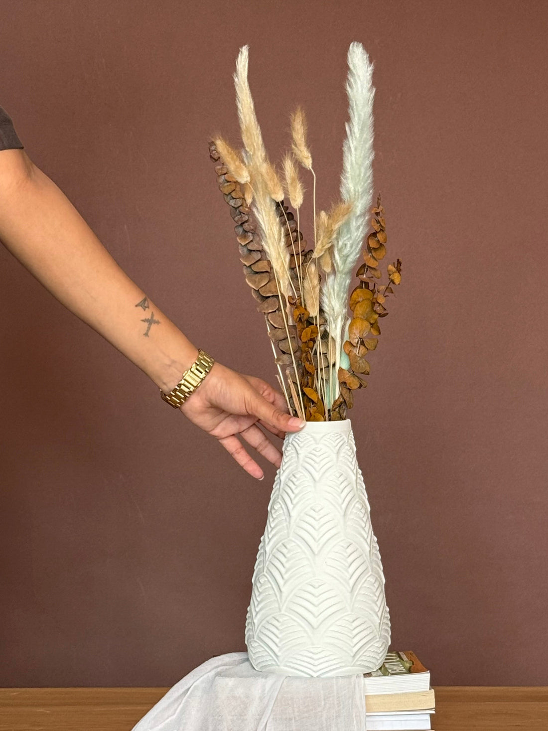 High Objects Elan Aura Vase with a stone-textured finish and sculptural silhouette, holding dried botanicals.