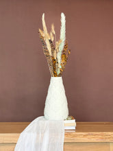 High Objects Elan Aura white textured vase with sculptural silhouette, holding dried botanicals.