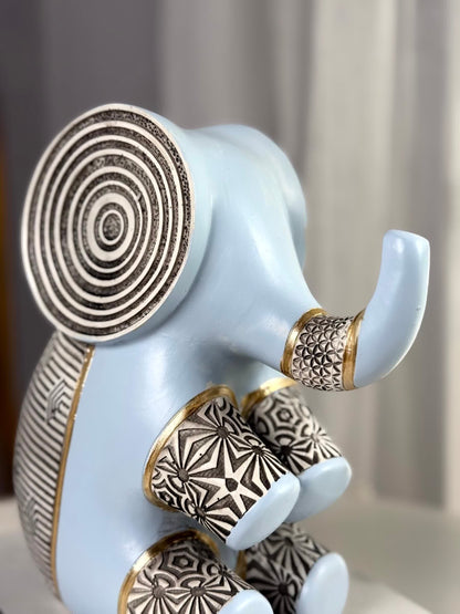 High Objects Elysian Trunk Figurine in soft blue polyresin with intricate black and white geometric patterns and gold accents.