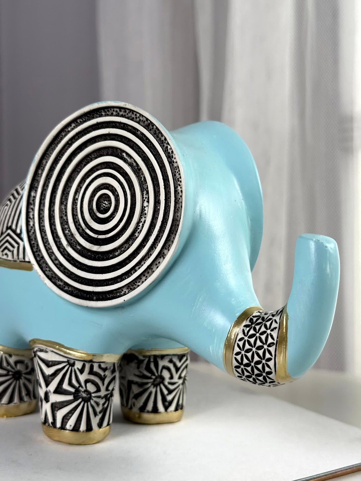 High Objects small blue polyresin elephant figurine with black and gold geometric patterns and concentric circles on ears.