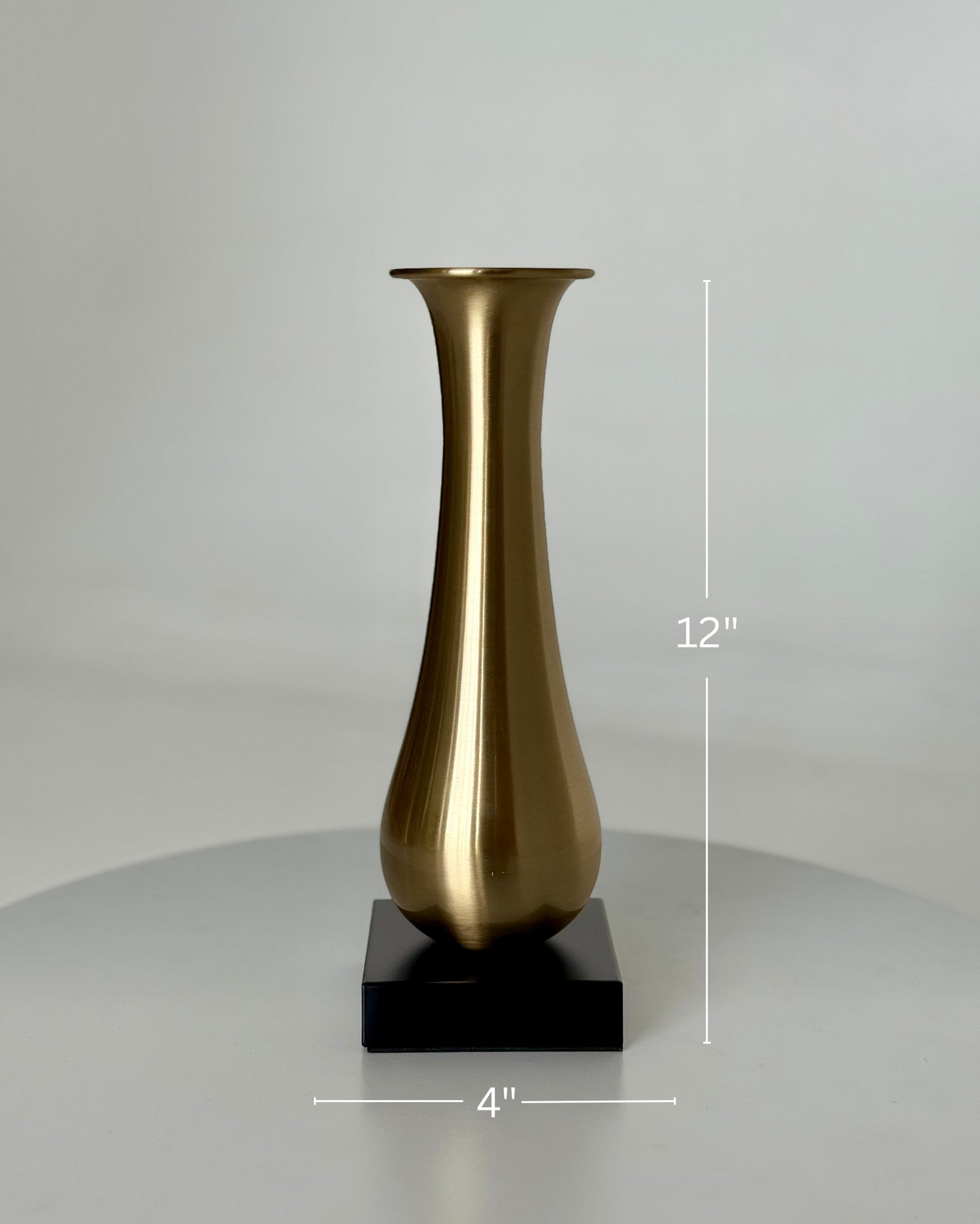 High Objects Eterna Gold Vase with a sleek, elongated silhouette and black square base. Brushed metallic finish.