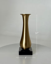 High Objects Eterna Gold Vase with a sleek, elongated silhouette and black square base. Brushed metallic finish.
